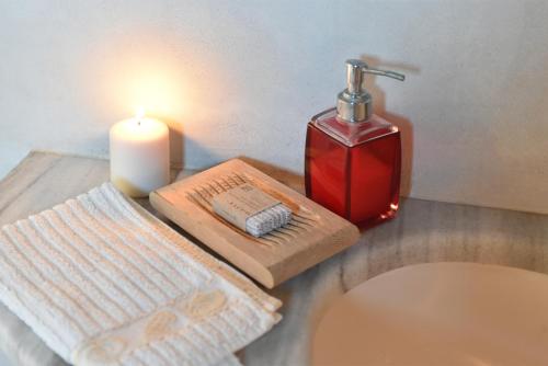 a candle and a soap dispenser on a table at Eagles Nest in Angairiá