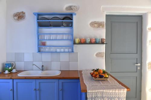 a kitchen with blue cabinets and a bowl of fruit on a counter at Eagles Nest in Angairiá