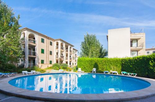 een zwembad met stoelen en een gebouw bij Codonyer A in Port de Pollença