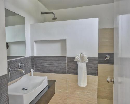 a bathroom with a white sink and a mirror at BlueBay Vacation Rentals at Vista Mare in Santa Bárbara de Samaná