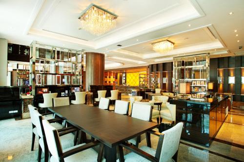 a dining room with a wooden table and chairs at Intimate Hotel Pattaya - SHA Extra Plus in Pattaya