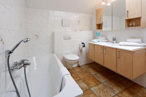 a bathroom with a tub and a toilet and a sink at Appartment Kinigadner in Pertisau
