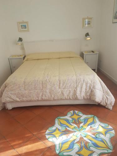 a bed in a room with two tables and a rug at Casa Lulù in Minori