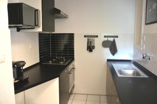 uma pequena cozinha com um lavatório e um fogão em Szőcs Apartment I. (80sqm, fully equipped+balcony) em Budapeste