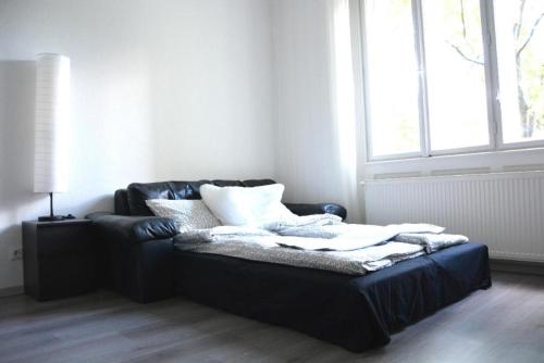 um sofá preto numa sala de estar com uma janela em Szőcs Apartment I. (80sqm, fully equipped+balcony) em Budapeste