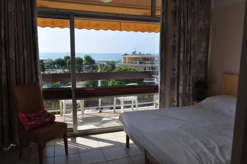 une chambre avec un lit et une fenêtre avec vue dans l'établissement Inter-Résidences Heliotel Marine, à Saint-Laurent-du-Var