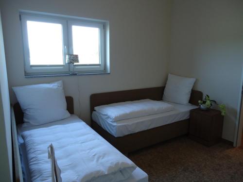 a small room with two beds and a window at Ostseehotel Boltenhagen in Boltenhagen
