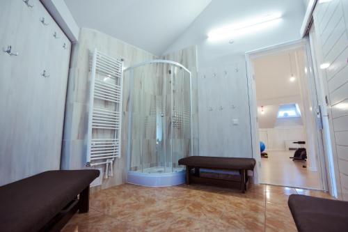 uma casa de banho com chuveiro e um banco num quarto em Hotel Insula em Tulcea