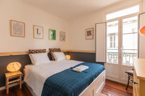 a bedroom with a bed and a desk and a window at Fantastic Family Apartment in Estrela in Lisbon