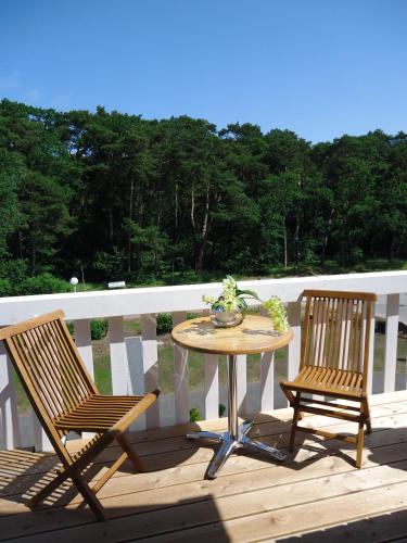 a table and two chairs on a deck at Ostseehotel Boltenhagen in Boltenhagen