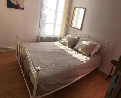 een bed met witte lakens en kussens in een slaapkamer bij House in Charleroi