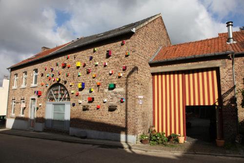 a brick building with a wall with colorful items on it at B&B De Henehoeve in Heks
