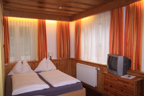 a small bedroom with a bed and a tv at Appartements Reiterhaus in Wagrain