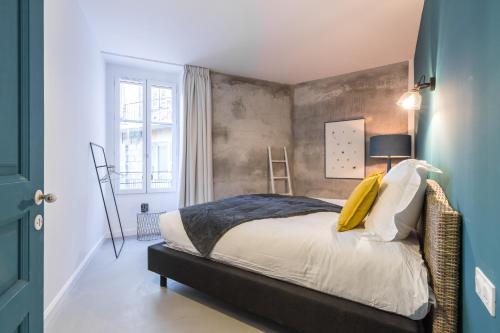 a bedroom with a bed and a wall at L'Abeille - Boutique Apartments in Nice