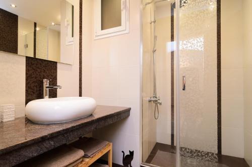a bathroom with a sink and a glass shower at Rise & Shine Sofia Luxury Apartment in Sofia