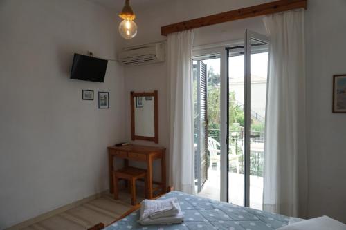 a bedroom with a bed and a mirror and a sliding glass door at Arillas Studios in Arillas
