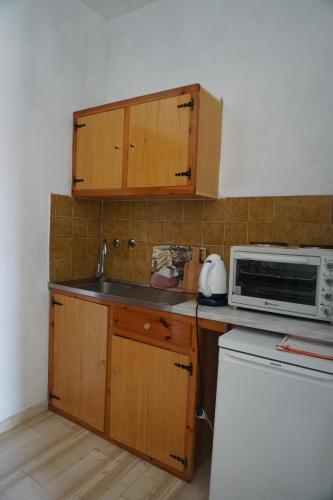 eine kleine Küche mit einer Spüle und einer Mikrowelle in der Unterkunft Arillas Studios in Arillas