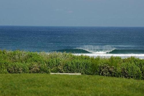 a view of the ocean from a field of grass at Logis Hôtel Le Relais in Biscarrosse