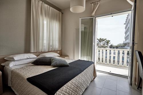 a bedroom with a bed and a large window at Rouge Hotel International in Milano Marittima