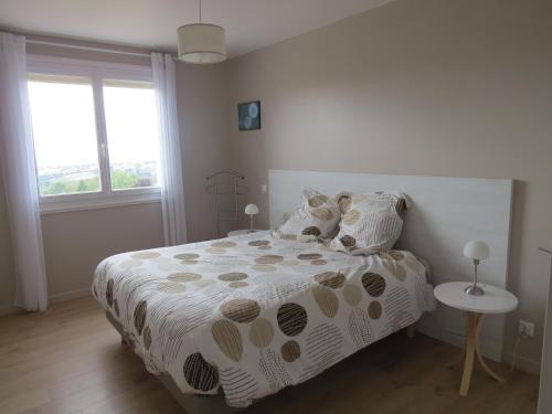 a white bedroom with a bed and a window at gite horizon in Neulise