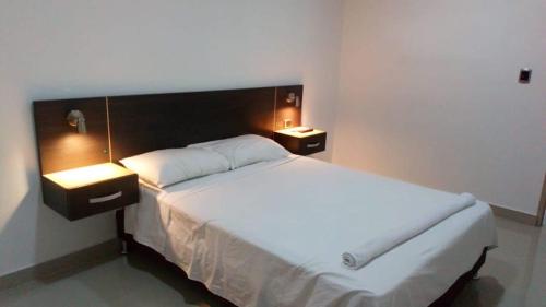 a bedroom with a large white bed with two lights at Hotel Boutique Martin's in Flandes