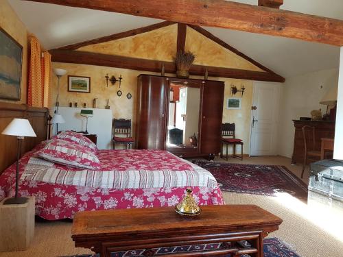 une chambre avec un lit et une table dedans dans l'établissement Gîte Aux Tournesols, à Malaucène