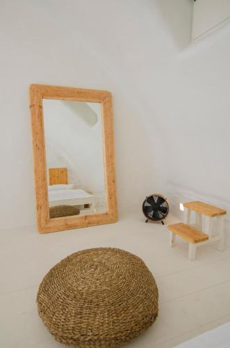 a mirror and other furniture on a white wall at Yialos Ios Hotel in Ios Chora