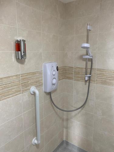 a shower in a bathroom with a shower head at Spacious semi detached house in Leigh