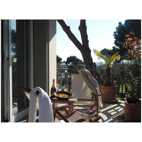 a patio with a table with a bottle of wine at Michelangelo rta in Cinquale