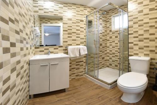a bathroom with a toilet and a glass shower at Zenbeach 1A playa carihuela in Torremolinos