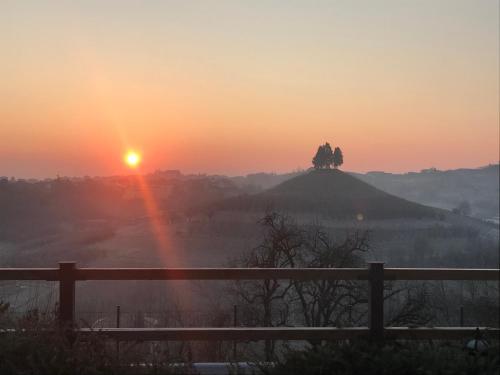 a sunset with a statue on top of a hill at Lange in Priocca