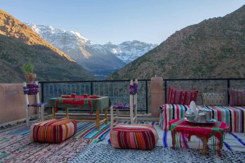 a balcony with chairs and tables and a view of mountains at Berber Family Lodge in Imlil