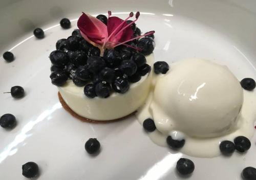 a dessert with blueberries and a flower on a plate at Bed&Bike Tremola San Gottardo in Airolo