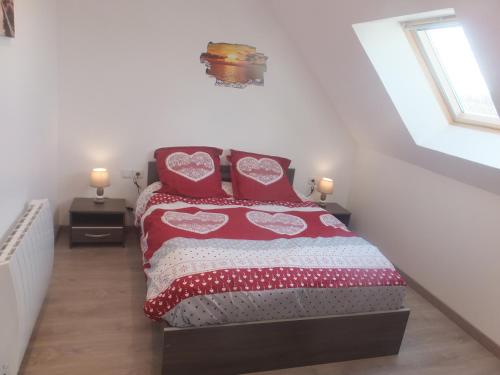 1 dormitorio con 1 cama con almohadas rojas en chez diane, en Barbeville