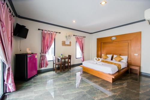 Numjaan Resort في مينْغكرابي: غرفة نوم بسرير كبير وطاولة