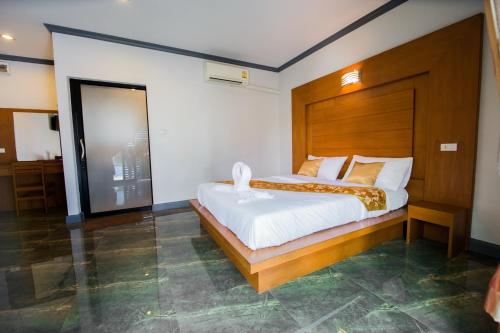 a bedroom with a large bed with a wooden headboard at Numjaan Resort in Krabi town