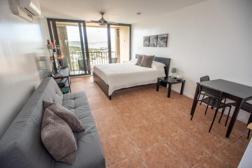 a living room with a couch and a bed and a table at Breathtaking Views of Sapphire Village in St Thomas