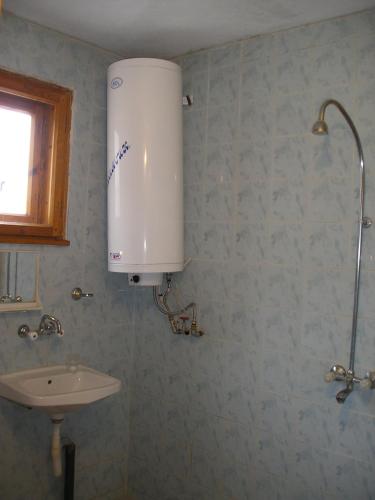 a bathroom with a sink and a water tank at Kristal Guest House in Trigrad