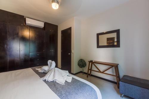 a bedroom with a bed with a towel on the floor at Via Tendenza Condos in Playa del Carmen