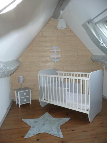 une pépinière avec un berceau et des étoiles au sol dans l'établissement Rose Cottage En Baie De Somme, à Nouvion-en-Ponthieu