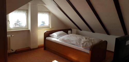 a small bed in a room with two windows at Hotel Kronberg in Kronberg im Taunus