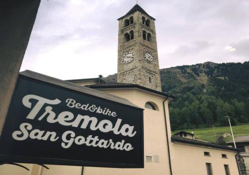 a clock tower on top of a building with a sign at Bed&Bike Tremola San Gottardo in Airolo