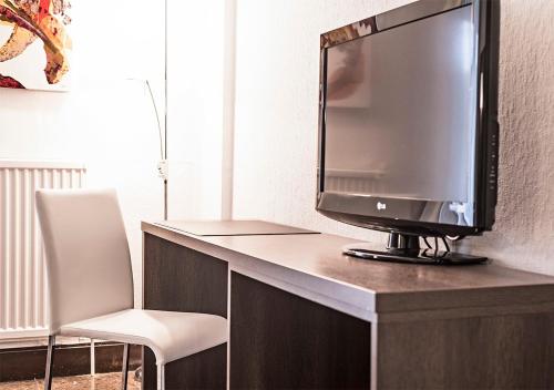 a tv sitting on top of a desk with a chair at Hotel Txartel in Lasarte