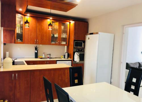 シオーフォクにあるAkácvirág Apartmanのキッチン(木製キャビネット、白い冷蔵庫付)