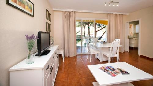uma sala de estar com televisão e uma sala de jantar em Leo Islamar na Islantilla