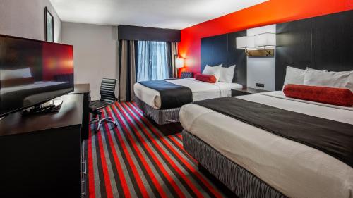 a hotel room with two beds and a flat screen tv at Comfort Inn & Suites Carrollton in Carrollton