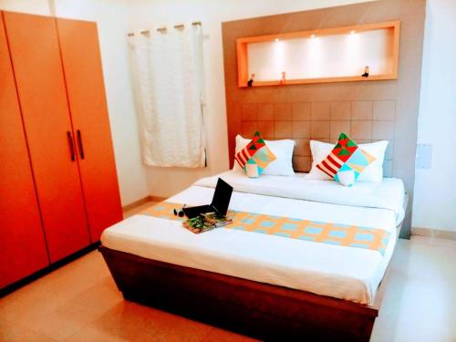 a bedroom with a bed with a laptop on it at KshiyOO Holiday Bungalow Resort in Pune