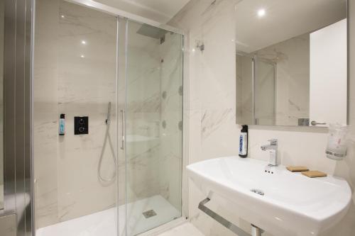 a white bathroom with a sink and a shower at Floris Hotel in Rome