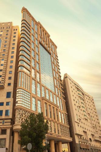 a tall building with many windows in a city at Violet Al Azizia Hotel MASJID Al Qatari in Makkah