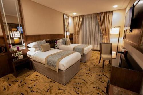 a hotel room with two beds and a television at Violet Al Azizia Hotel in Mecca